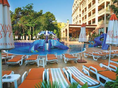 Rekreační oblast s bazénem, skluzavkami a lehátky před hotelem.