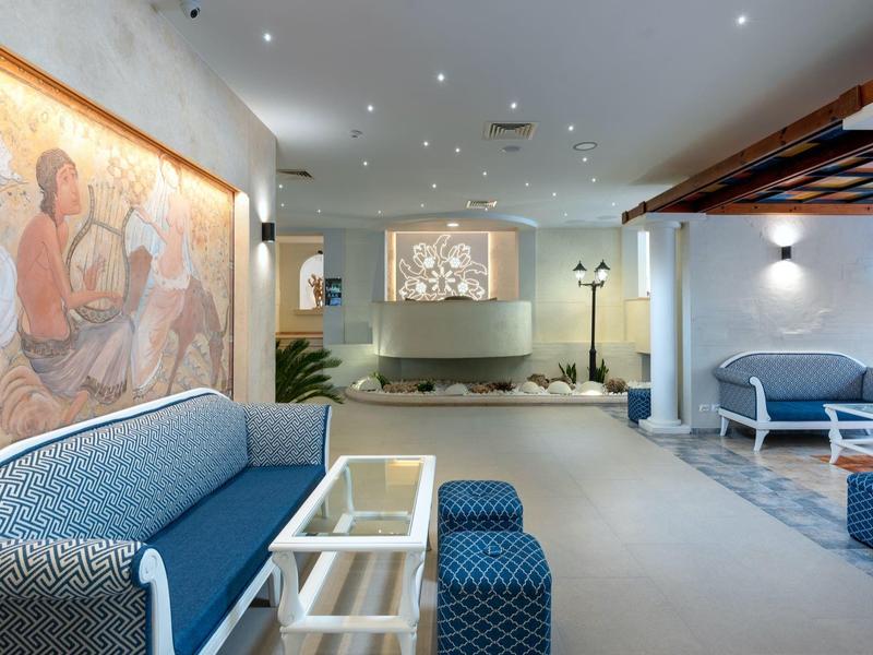 Moderne hotel wachtruimte met blauwe kussens, kunstmuur en stijlvolle verlichting.