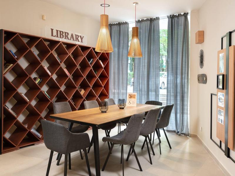 Moderne leesruimte met houten planken, tafel en stoelen bij raam met gordijnen