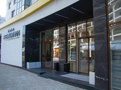 Hotelentree met grote glazen ramen en zwarte wandbekleding.