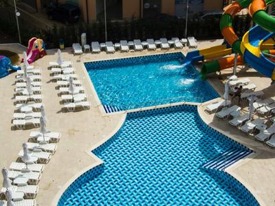 Groot hotelzwembad met glijbaan en ligstoelen eromheen.