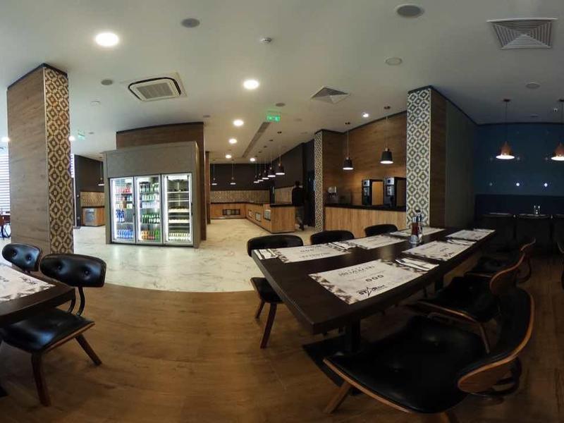 Ruime, lichte eetruimte met gedekte tafels en stoelen, moderne inrichting.