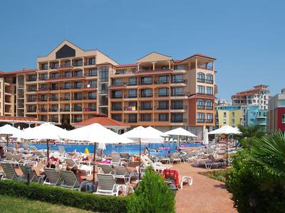 Meerverdieningshotel met zwembad en ligstoelen onder een heldere lucht