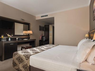Moderne hotelkamer met groot bed, flatscreen-tv en bureau.