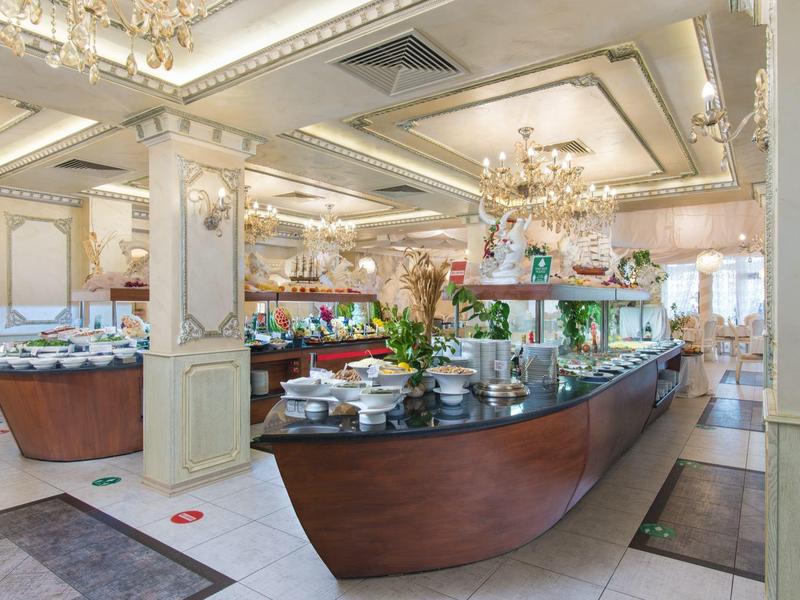 Elegante buffetruimte in een hotel met grote spiegels en kroonluchters.