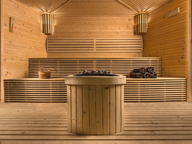 Houtsauna met banken, kachel en handdoeken in warm licht
