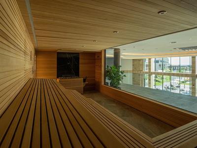 Interieur van een sauna met houten bekleding en groot raam met uitzicht naar buiten.