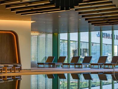 Moderne binnenzwembad met ligstoelen en warme verlichting in een hotel.