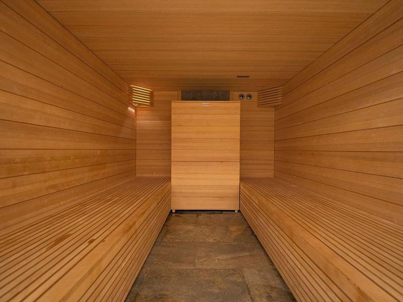 Binnenkant van een traditionele houten sauna met banken langs de zijkanten.