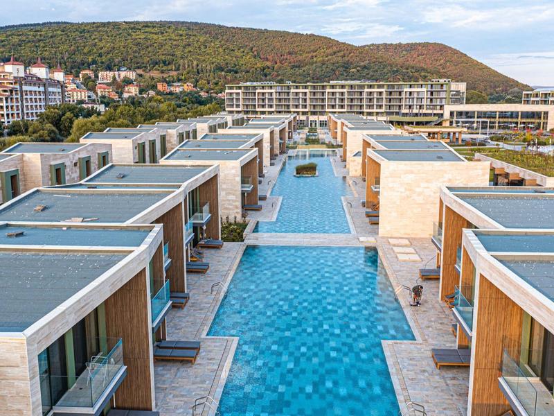 Moderne vakantieappartementen met lange zwembaden en uitzicht op de bergen.