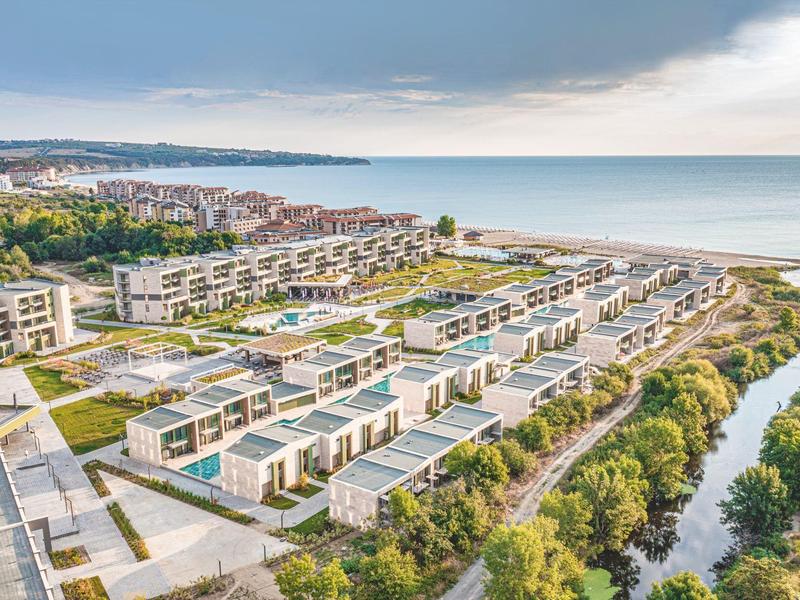 Moderne vakantie villa's aan de kust met zeezicht en beboste oevers.