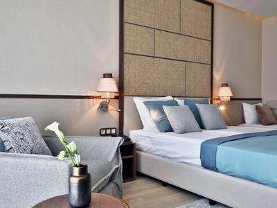 Modernes Hotelzimmer mit einem großen, bequemen Bett und einem Sitzbereich mit Sofa.