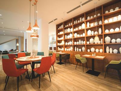 Hôtel moderne avec piscine extérieure et chaises longues au coucher du soleil.