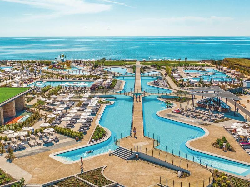 Ein luxuriöses Resort mit großen Pools, Sonnenterrassen und Blick auf das Meer.