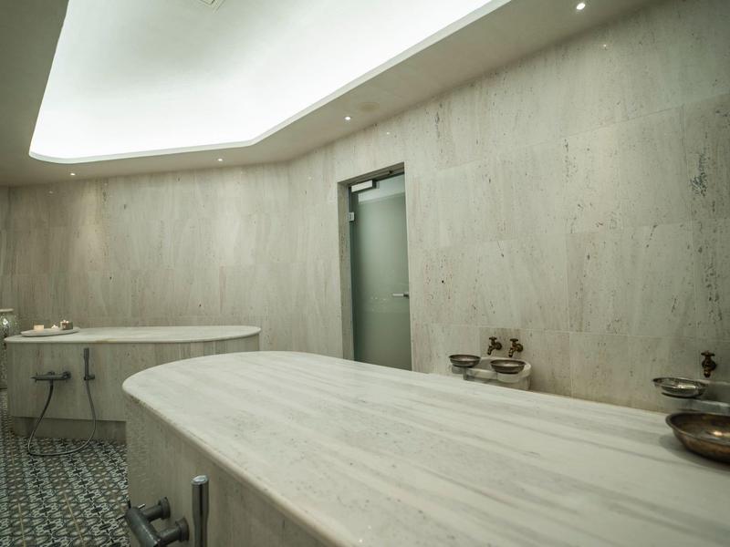Heller, moderner Hammam-Raum mit gewölbter Decke und Marmorwaschbecken