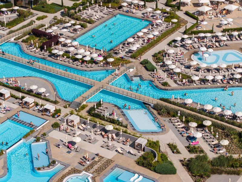 Luftaufnahme eines weitläufigen Wasserparks mit zahlreichen Pools und Rutschen.