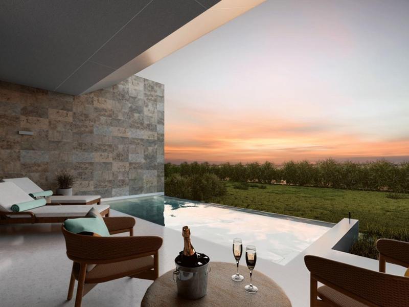 Moderner Außenbereich mit Infinity-Pool und Sitzgelegenheiten bei Sonnenuntergang.