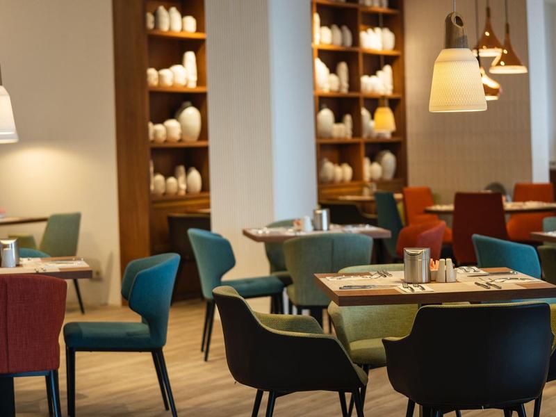 Gemütlicher Essbereich mit modernen Stühlen und warmem Licht in einem Hotelrestaurant.