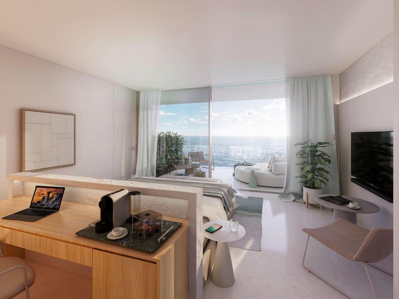 Modernes Hotelzimmer mit Balkon und Sitzbereich mit Blick auf das Meer.