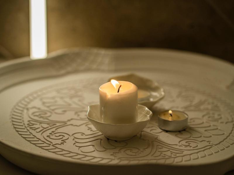 Kerzen auf einem dekorativen großen runden Tisch, ideale Stimmung für Entspannung im Hotel.
