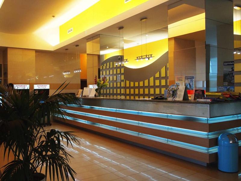Modern hotel reception with illuminated counter and warm lighting ambiance.