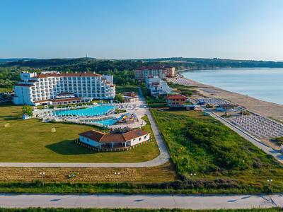 Grande hotel con piscina, spiaggia e ampio verde vicino al mare.