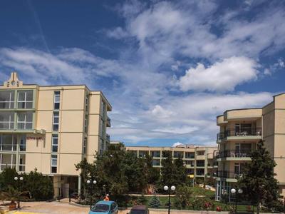 Modern hotel complex with multiple buildings under a blue sky with clouds