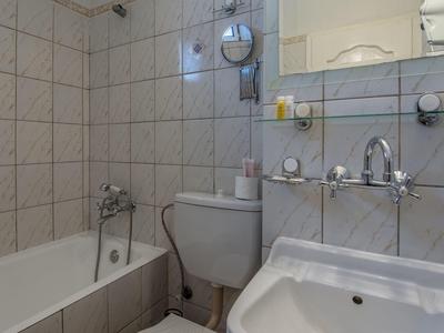 Piccolo bagno con vasca, lavabo, gabinetto e specchio a parete.