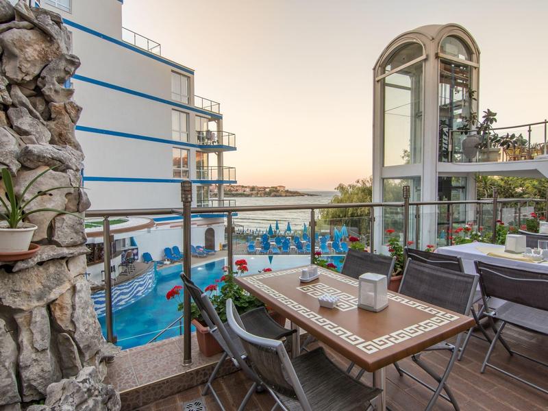 Terrazza con vista piscina, tavoli e sedie, luce serale mediterranea