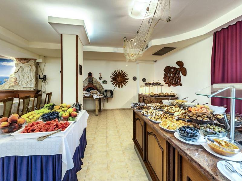 Area buffet con una varietà di piatti e frutta fresca in un ristorante dell'hotel.