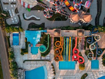 Luchtfoto van een groot waterpark met meerdere zwembaden, glijbanen en kronkelende waterbanen.