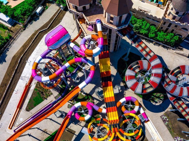 Kleurrijke glijbanen en zwembaden in een kasteelthemapark.