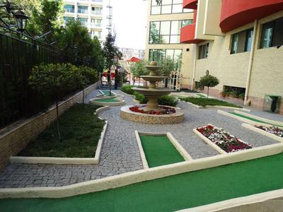 Parcours de mini-golf avec fontaine à côté d'un bâtiment d'hôtel