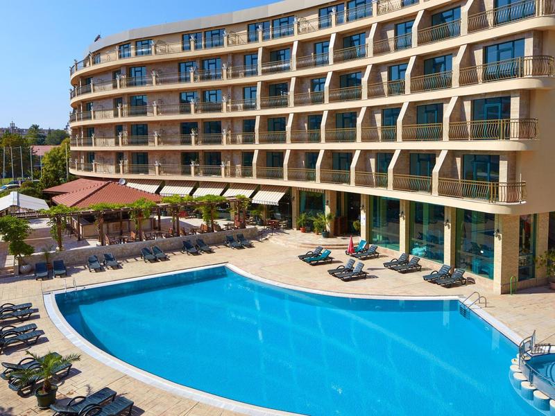 Moderner Hotelkomplex mit geschwungenem Design und großem Außenpool im sonnigen Wetter.