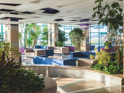 Helles Hotel-Lobby mit moderner Sitzgruppe und viel natürlichem Licht.