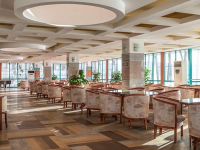 Großer, heller Hotel-Loungebereich mit bequemen Sesseln und großen Fenstern.