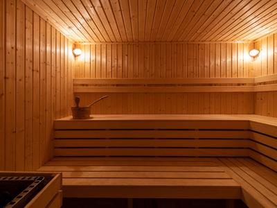 Traditionelle Holzaussensauna mit Bänken und warmem Licht.