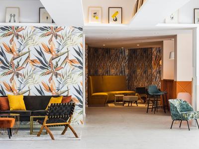 Moderne hotellounge met kleurrijke stoelen en patroonmuren.