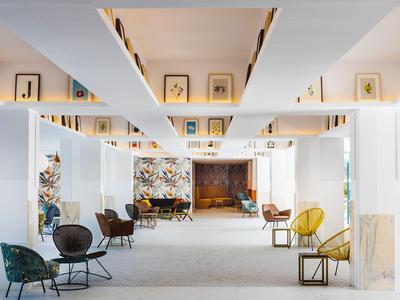 Modern hotel lobby-interieur met kleurrijke stoelen en abstracte kunst aan de muur.