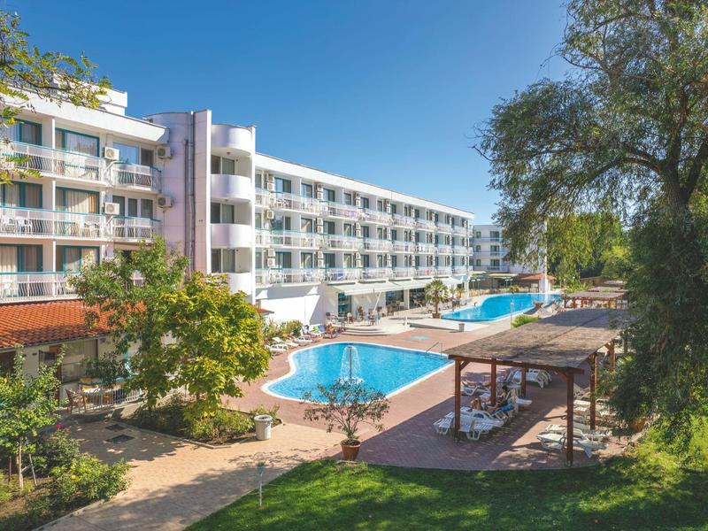 Moderner mehrstöckiger Hotelkomplex mit großem Außenpool und Liegeflächen bei klarem Himmel.