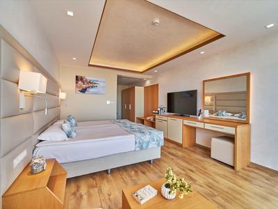 Modern hotelkamer met twee bedden, bureau, flatscreen-tv en houten vloer.