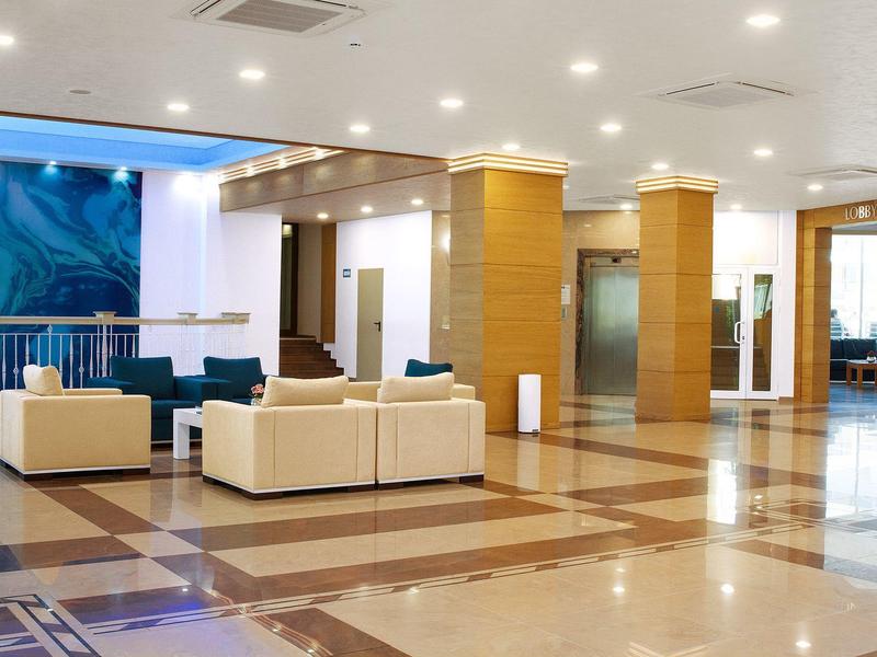 Lichte hotel lobby met moderne meubelset en marmeren vloer.