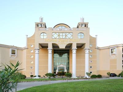 Budynek hotelu z kolumnami i symetryczną architekturą na tle niebieskiego nieba
