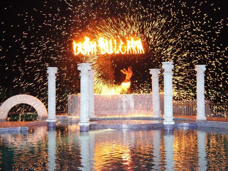 Fuochi d'artificio e spettacolo di luci sull'acqua con insegna illuminata di notte