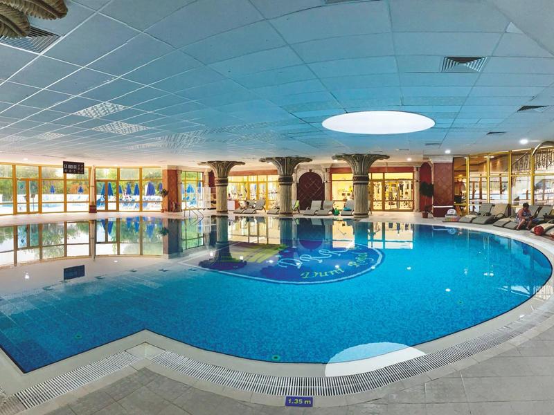 Grande piscina interna con piscina rotonda e ambiente spazioso.