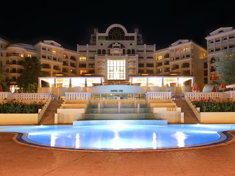 Hotel illuminato con piscina e terrazza di notte.