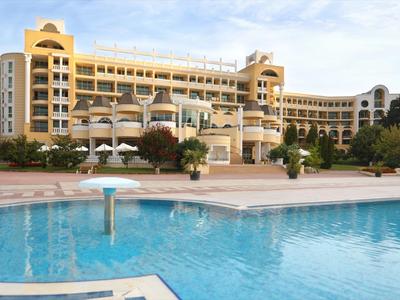 Groot hotelgebouw met meerdere verdiepingen en een groot zwembad op de voorgrond