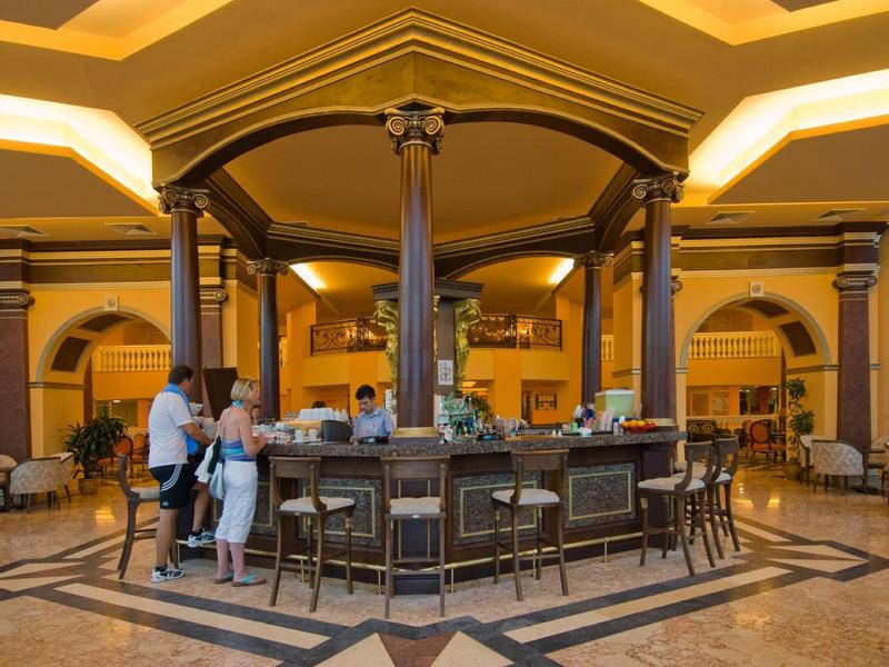 Hotelbar met ronde balie en gasten in een elegante, warm verlichte binnenruimte.