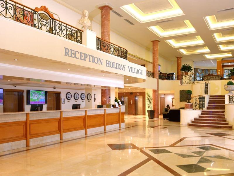 Ruime hotellobby met receptie, marmeren vloer en decoratieve trap