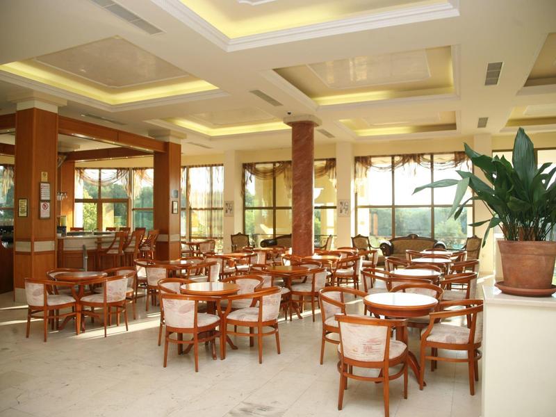 Lichte hotel eetruimte met houten meubels en planten in potten